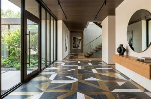 Contemporary entryway featuring bold geometric floor tiles in charcoal and brass