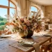 Large dried floral summer centerpiece on a wooden dining table in a sunlit room.