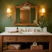 Cozy olive green powder room with brushed brass sconces and natural wood vanity