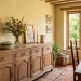 Timeless oak buffet in a sun-drenched classic vintage dining room with rustic stone pitchers.