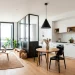 Bright studio apartment featuring white walls and modern matte black accents.