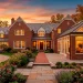 Beautiful seamless sunroom addition blending perfectly with a classic brick home exterior at sunset