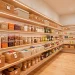Beautifully organized modern kitchen pantry with clear bins and woven baskets on wooden shelves.