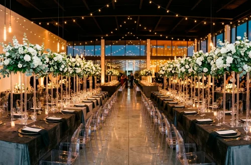 Modern ghost-chic wedding reception featuring clear acrylic chairs, charcoal velvet linens, and floating floral arrangements.