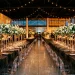 Modern ghost-chic wedding reception featuring clear acrylic chairs, charcoal velvet linens, and floating floral arrangements.