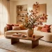 Modern organic living room with earthy fall decor, terracotta pillows, and dried branches on a wood table.