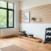 Bright minimalist home gym in a small apartment with sleek oak floors, neat dumbbell rack, and natural light.