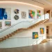 Wide horizontal view of a modern luxury staircase featuring a sophisticated gallery wall with artwork and LED lighting.
