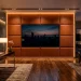 Luxurious executive suite featuring a sleek flat-screen TV mounted on a rich cognac leather-wrapped accent wall with LED backlighting.