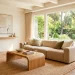 Organic modern living room featuring a cozy boucle sofa, light oak wood coffee table, and an olive tree.