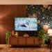 Eclectic living room TV wall featuring mixed textures of fluted wood and dark floral wallpaper.