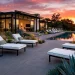 Luxurious modern monochrome patio with charcoal concrete pavers and black and white lounge chairs.