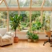 Wide view of a bright small sunroom featuring space-saving furniture and lush indoor plants.