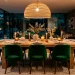 Cozy modern dining room layered with soft textures like velvet chairs and a chunky rug