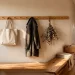 Beautifully styled narrow hallway featuring a long wooden peg rail with a wool coat and canvas bag.