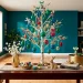 A white Easter tree decorated with emerald and sapphire jewel-toned ornaments in a modern teal living room.