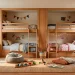 A small shared kids bedroom decorated with warm oak furniture, featuring wooden bunk beds and soft sunlight.