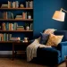 Wide view of a moody indigo bedroom reading nook with a velvet armchair and brass floor lamp