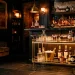 Luxurious home bar setup featuring a glowing metallic gold rolling cart and crystal glasses in a moody room