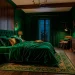 Luxurious moody bedroom featuring emerald green walls and glowing brass accents