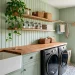 Cozy cottage laundry room with sage green beadboard, butcher block counters, and a farmhouse sink