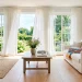 Bright summer living room featuring a hand-woven seagrass basket filled with throw blankets next to a white sofa.