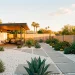 Wide view of a retro minimalist backyard with succulents, white gravel, and mid-century modern design elements