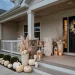 Sophisticated bone-white Halloween porch decorations featuring pale pumpkins and ceramic skulls.