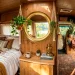 Bright and airy camper van interior featuring a large round brass mirror reflecting sunlight