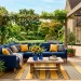 Sophisticated Memorial Day patio featuring a navy sofa, mustard yellow pillows, cobalt blue vases, and vibrant summer decor.