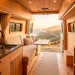 Clean and clutter-free interior of a luxury camper van showcasing clever minimalist storage solutions.