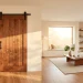 A modern living room featuring a stunning rich walnut wood sliding barn door with matte black hardware in bright natural light.