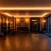 Luxurious masculine home gym with rich dark espresso wood floors and matte black fitness equipment