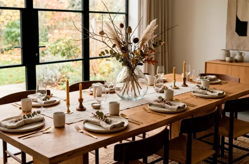 Minimalist Japandi Thanksgiving table setting with a clear glass vase centerpiece and dried branches