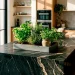 Matte grey herb tray on a modern dark stone kitchen island bathed in sunlight.