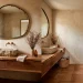 Organic modern powder room featuring a raw wood vanity, textured plaster walls, and warm terracotta floor tiles.
