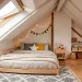 Cozy minimalist Montessori floor bed tucked under a sloped attic ceiling with warm natural lighting.
