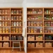 Beautifully organized custom kitchen pantry with wooden shelves, clear acrylic bins, and woven baskets.