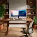 Modern home office with a neatly organized walnut standing desk, ergonomic chair, and minimal decor in bright natural light.