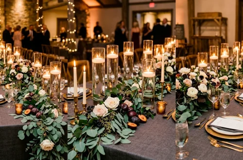 Luxurious DIY wedding tablescape with eucalyptus runner, white roses, and floating candles