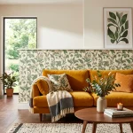 Contemporary living room with botanical removable wallpaper and a mustard velvet sofa in bright sunlight.