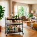 Sleek matte black portable bar cart styled with crystal glasses in a bright modern living room.