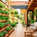 A beautifully styled small porch featuring lush vertical herb gardens and cozy seating.