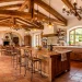 Stunning Mediterranean kitchen featuring warm reclaimed wood beams, terracotta floors, and elegant wrought iron lighting.
