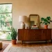 Restored vintage wooden credenza in a stylish, cozy living room bathed in natural sunlight.
