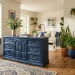 Modernized antique wood dresser painted matte navy blue in a bright, stylish living room setting.