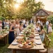 Beautiful rustic outdoor food station at a lively backyard wedding reception during golden hour.
