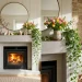 Beautiful spring mantel decor featuring whimsical figurines, fresh tulips, and trailing ivy in a sunlit living room.