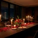 Romantic anniversary dinner table setting illuminated by warm candlelight and brass candelabras