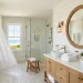 Wide view of a coastal bathroom with nautical vanity sconces and white shiplap walls